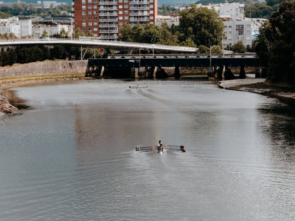 Ruderer auf einem Fluss vor Stadtansicht