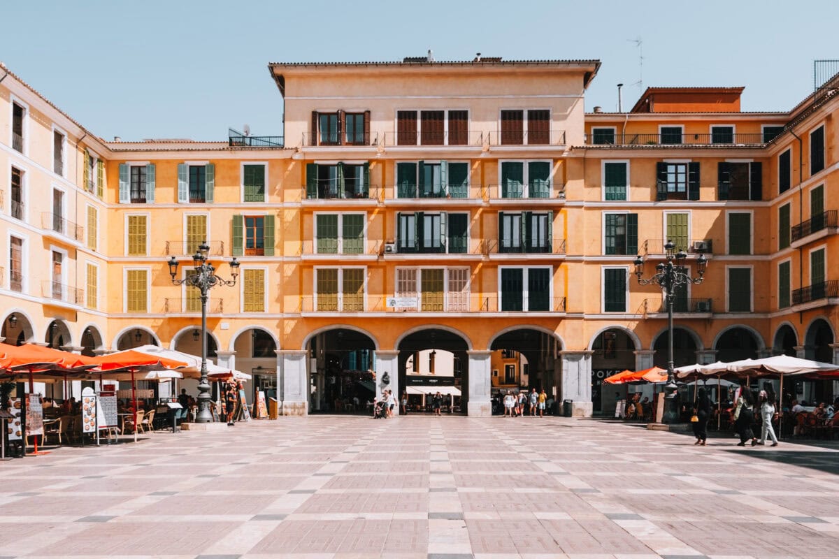 Leerer Platz vor einem historischen Gebäude mit Arkaden.