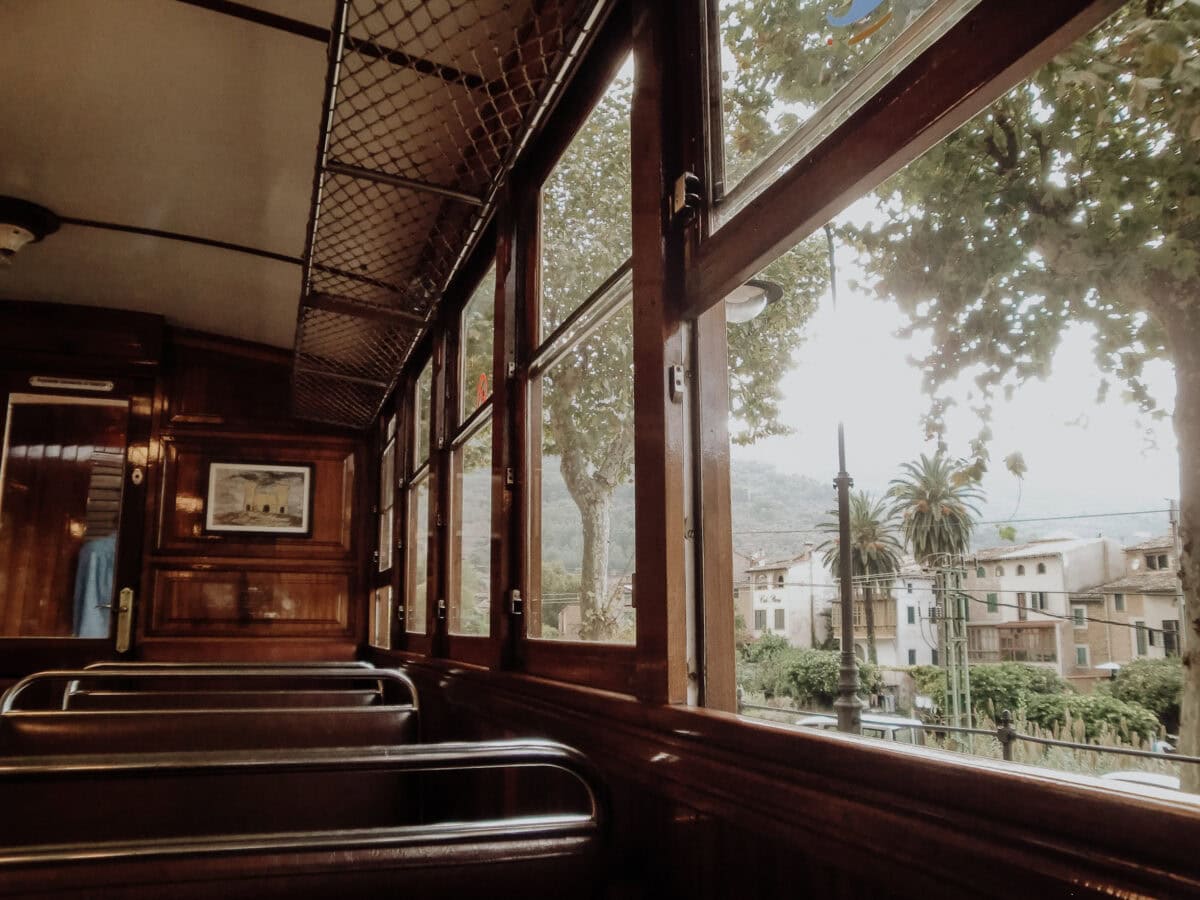 Altes Zugabteil, Ausblick auf Bäume und Gebäude.
