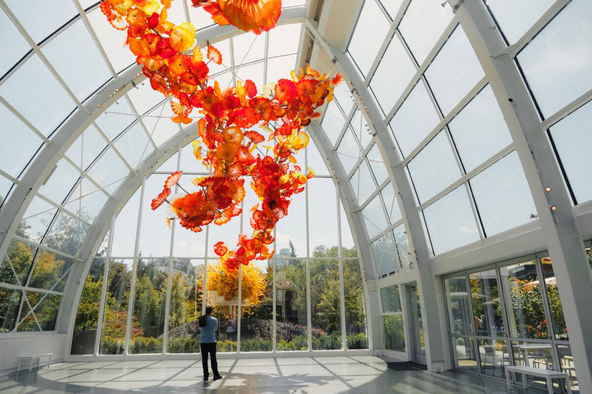 Blumen aus buntem Glas in einem großen Glashaus.