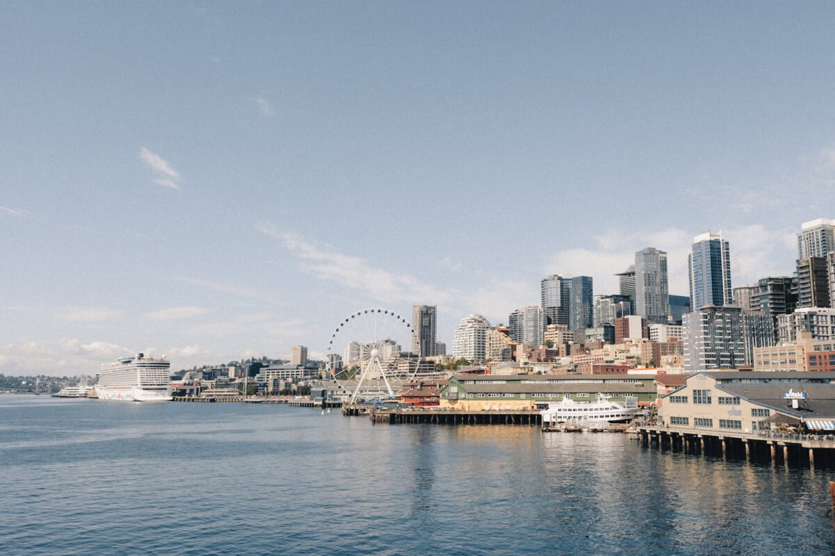Ufer einer Großstadt mit Hochhäusern und Kreuzfahrtschiff