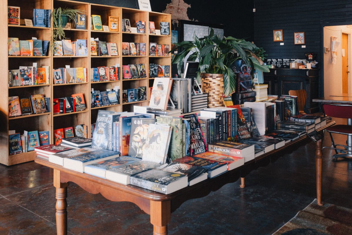 Buchhandlung mit Regalen und Büchern auf einem Tisch.