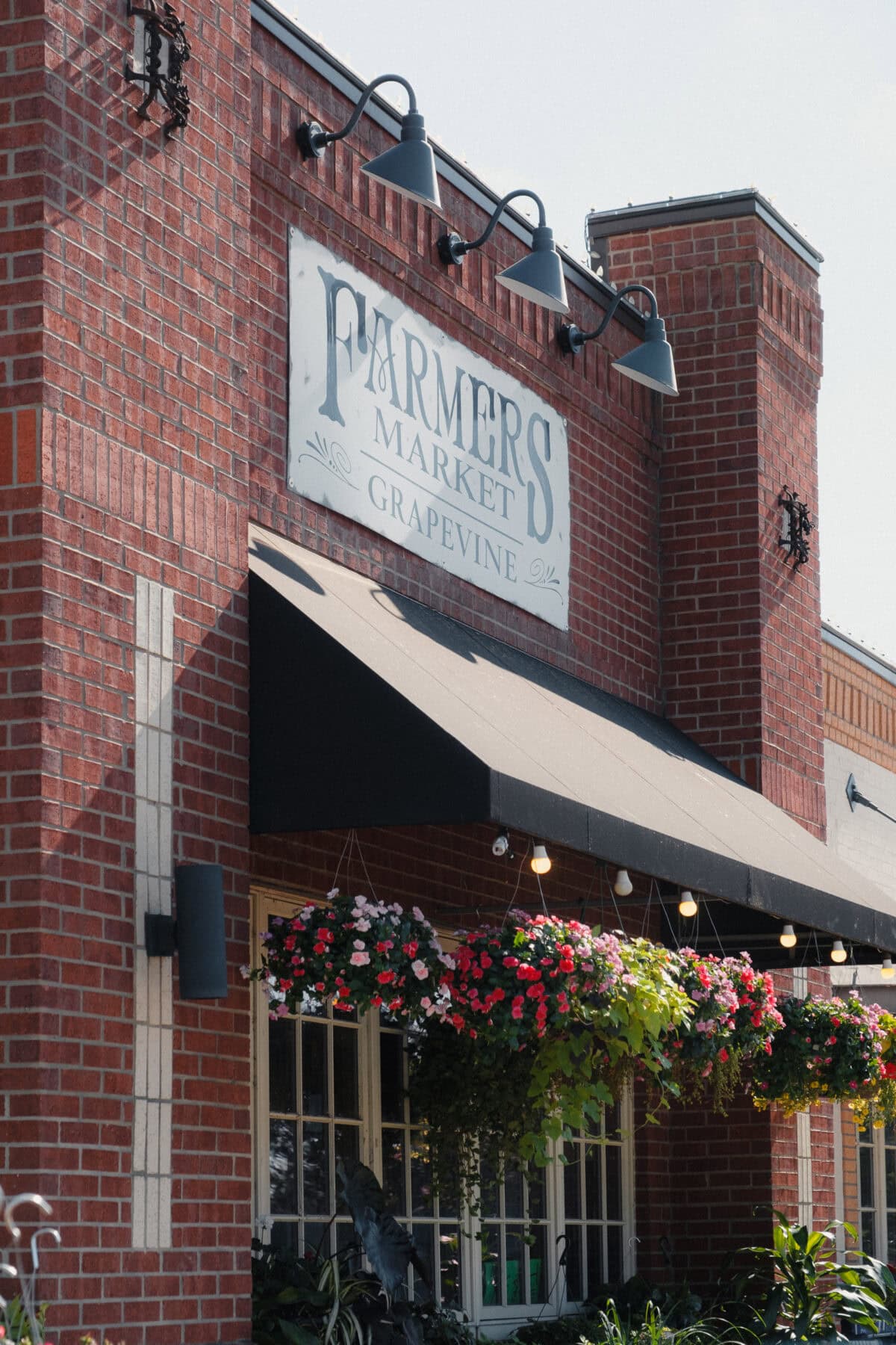 Eingang eines Bauernmarktes mit Blumen.