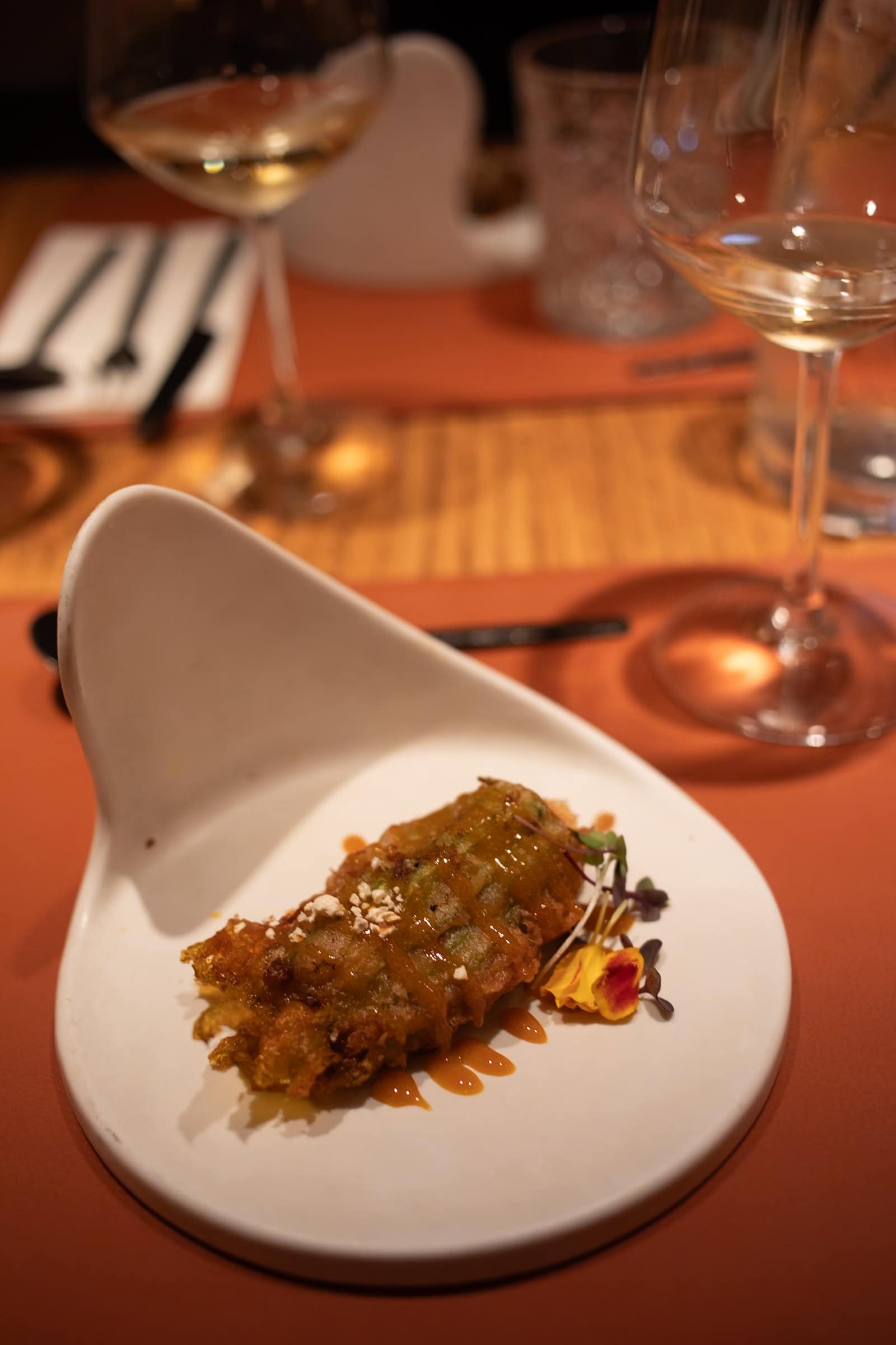 Frittierte Vorspeise auf elegantem Teller serviert.