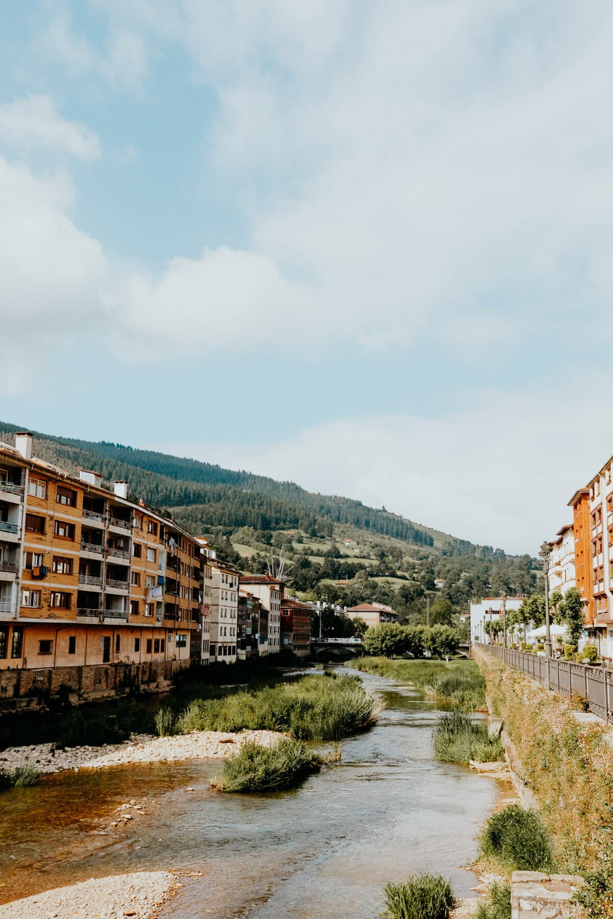 Fluss fließt durch Stadt mit hügeliger Landschaft.