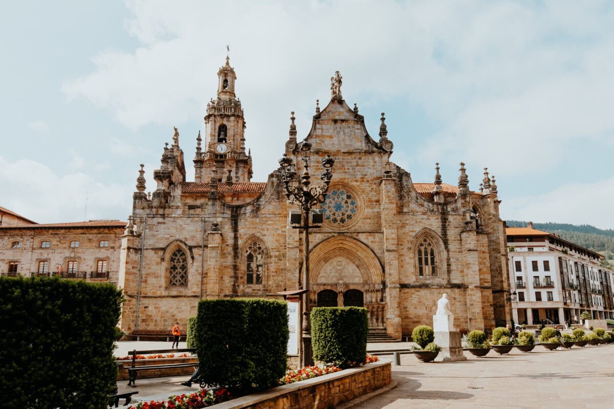 Historische Kirche mit Turm vor blauem Himmel.