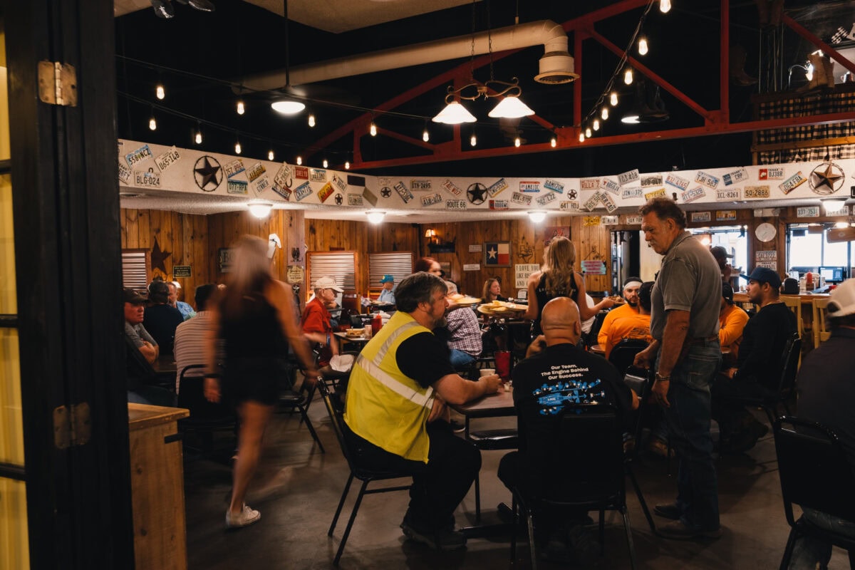 Volles Restaurant mit Menschen und Dekorationen.