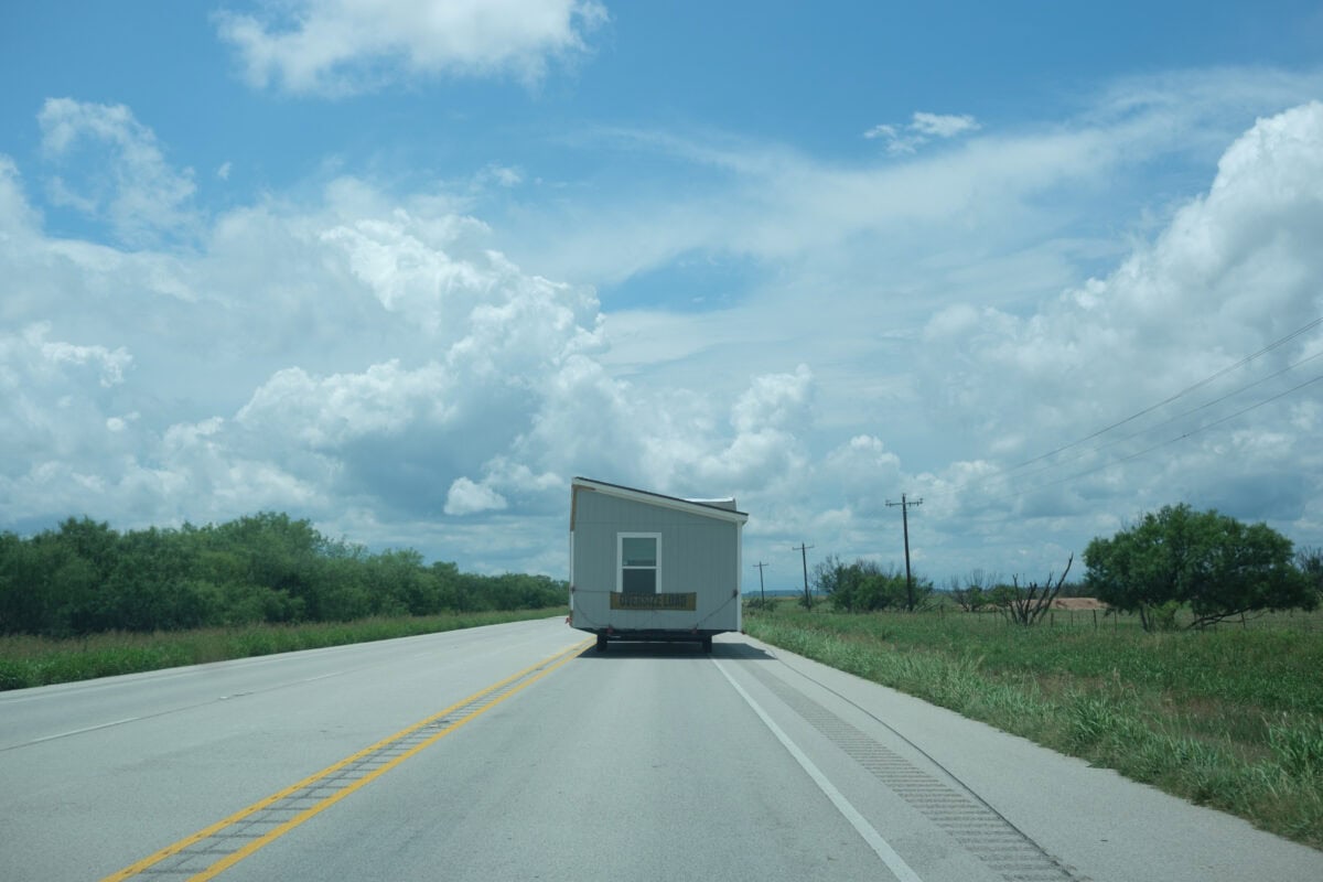 Haus auf Rädern auf ländlicher Straße transportiert