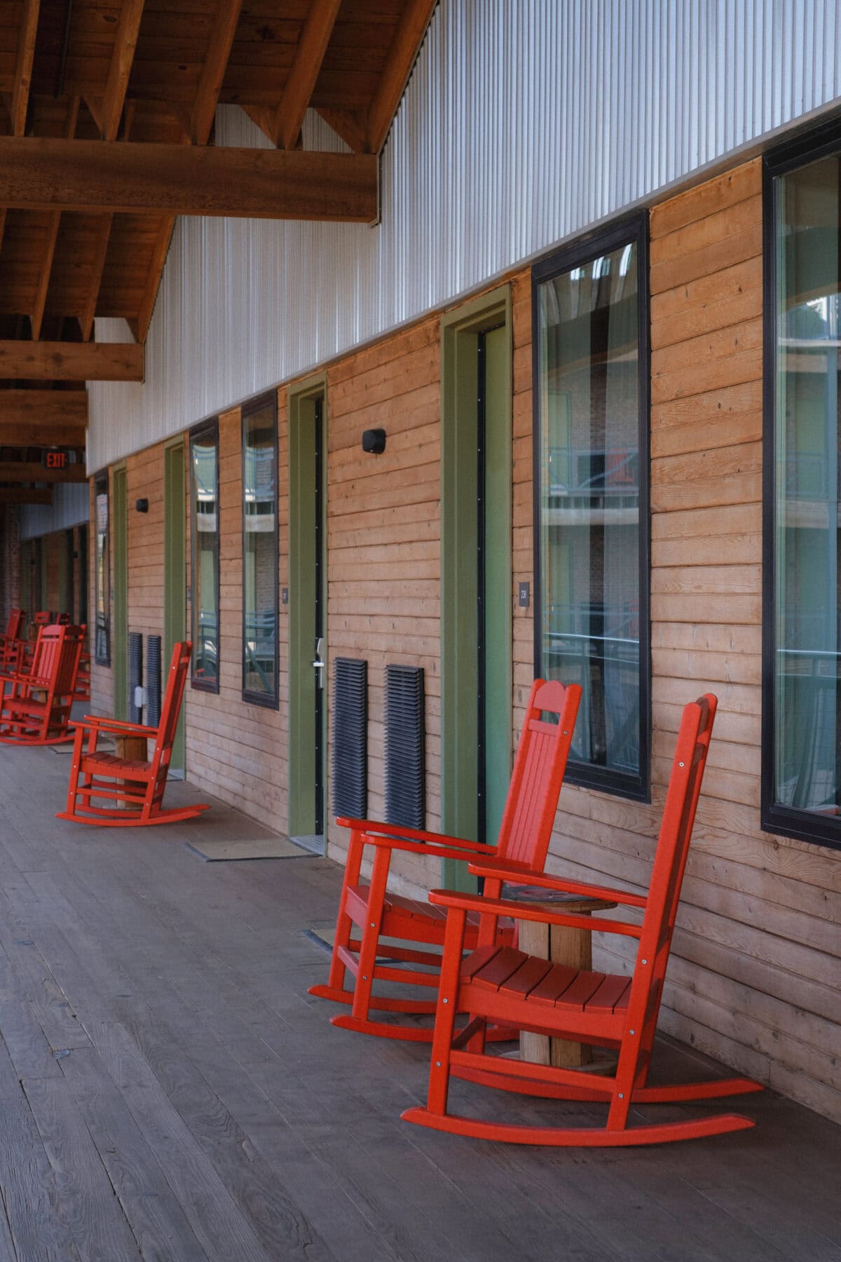 Rote Schaukelstühle auf hölzernem Balkon