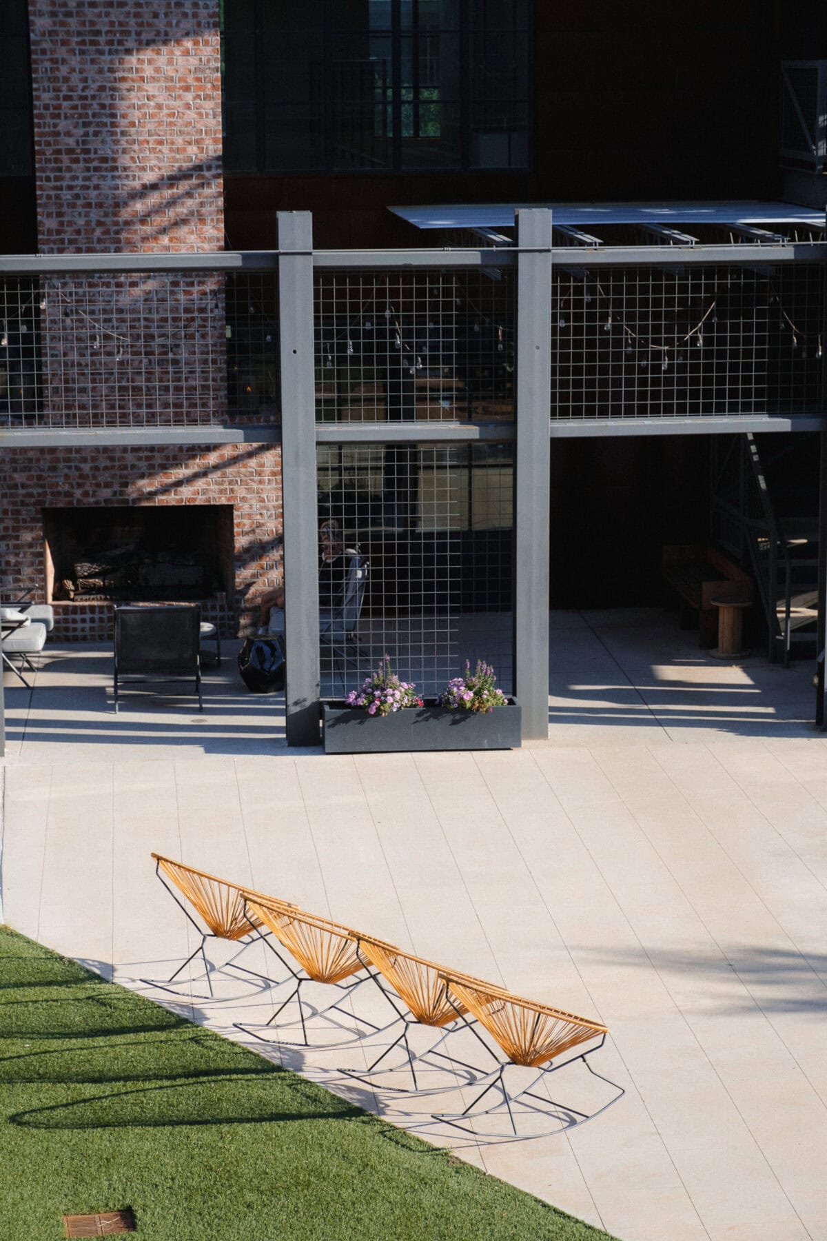 Moderne Terrasse mit Sitzmöglichkeiten und Ziegelwand.