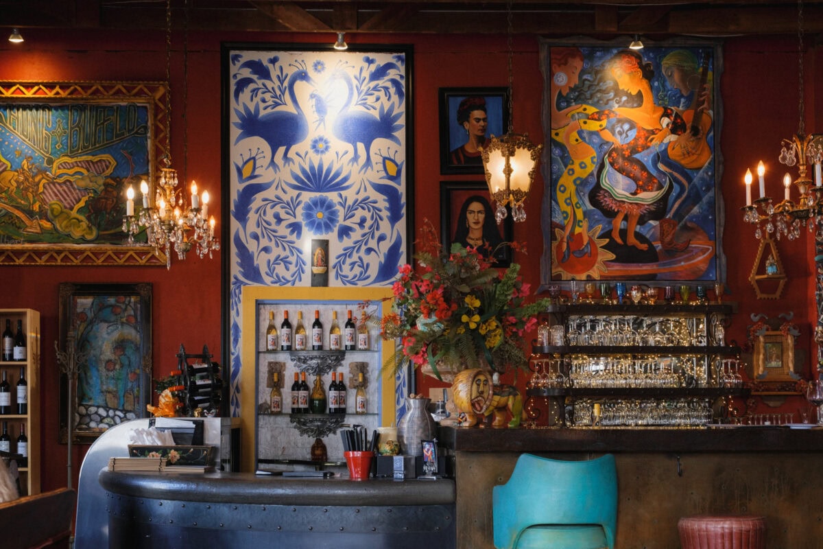 Bunte Bar mit dekorativen Wandgemälden und Flaschen.