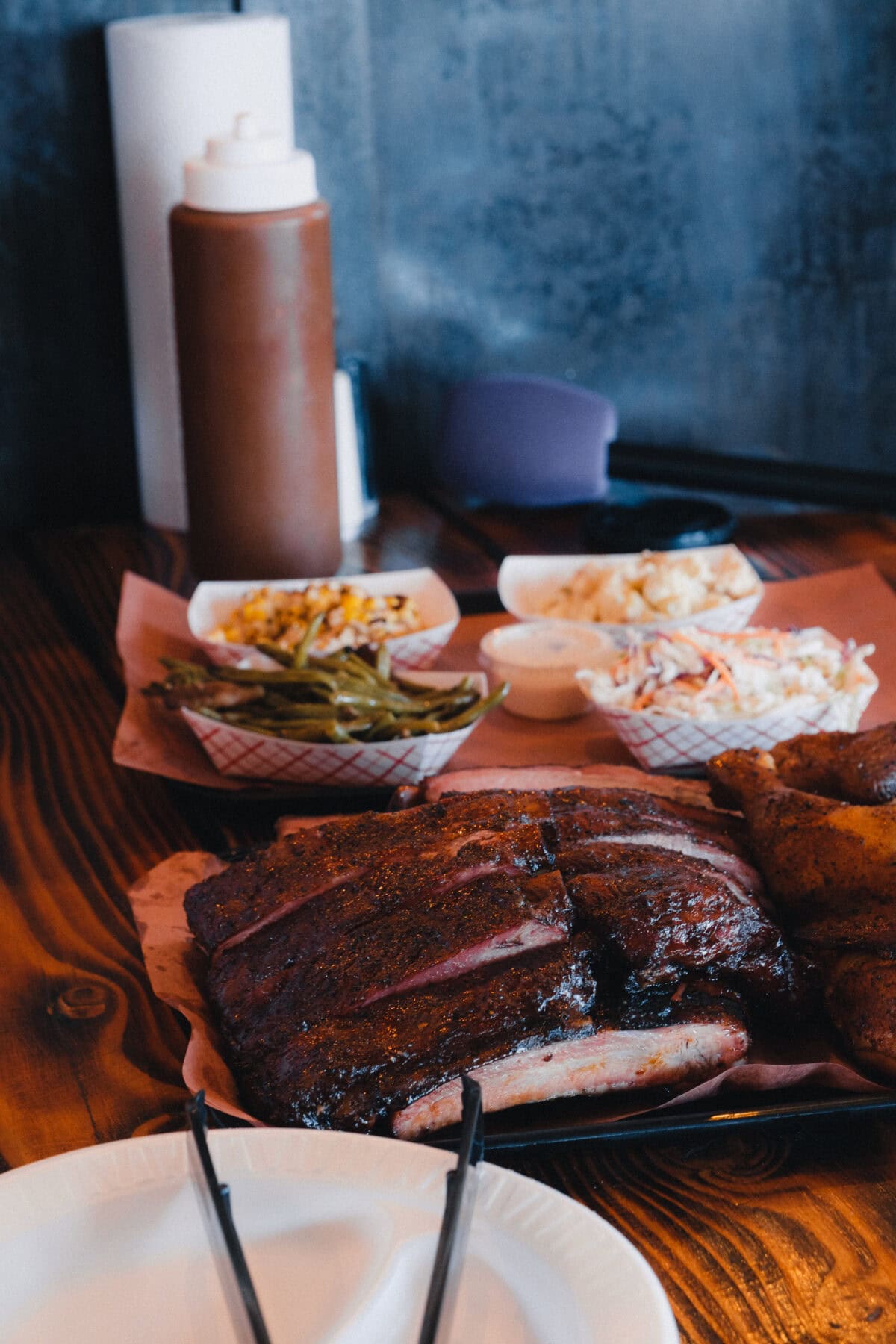 Barbecue-Gericht mit Beilagen auf Holztisch
