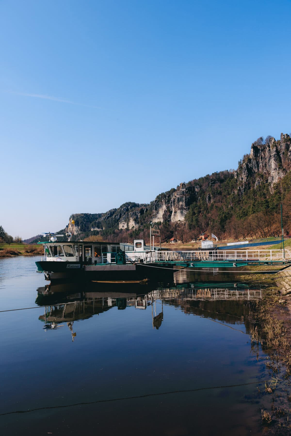 Ferry on the river in front of a rocky landscape