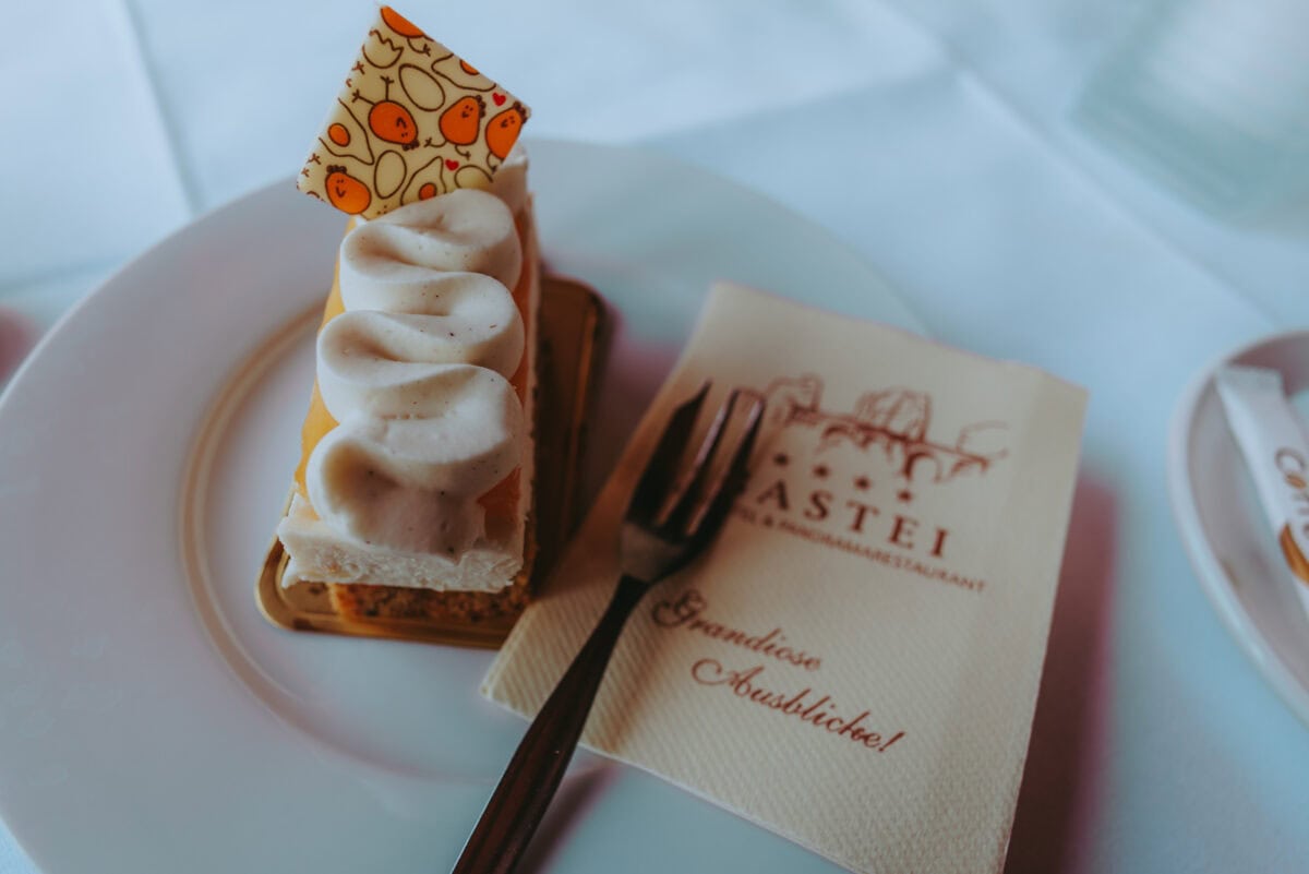 Piece of cake with cream topping on a white plate