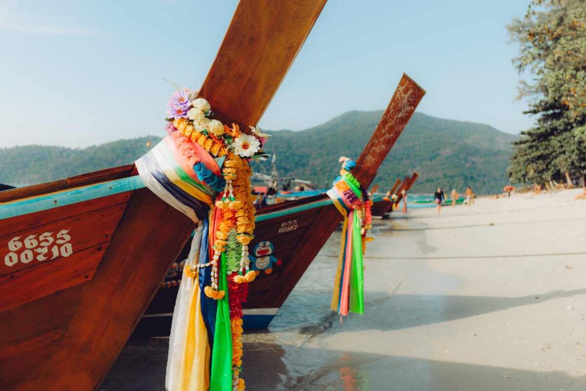 Bunte Longtail-Boote am tropischen Strand