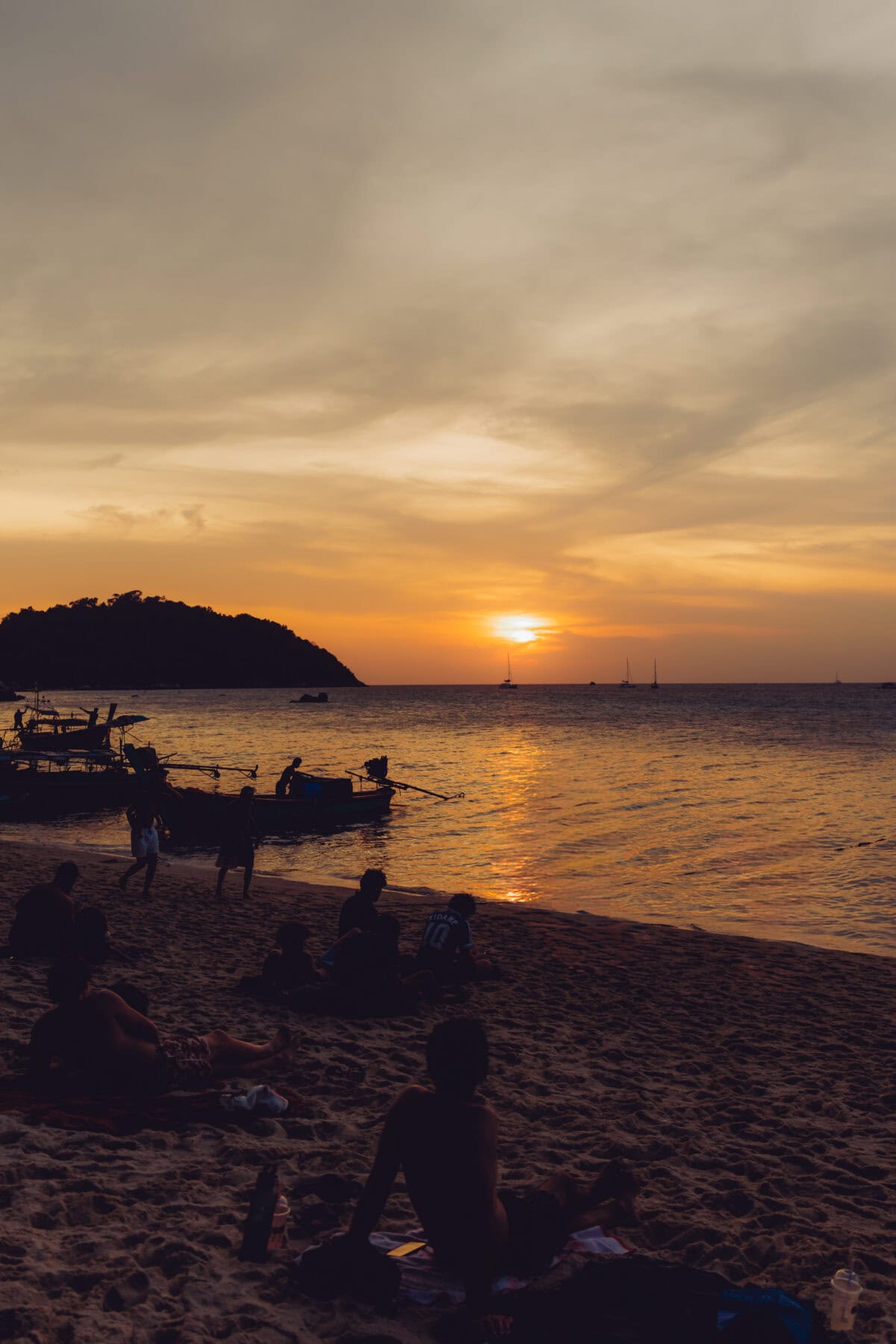Sonnenuntergang am Strand mit Booten und Silhouetten