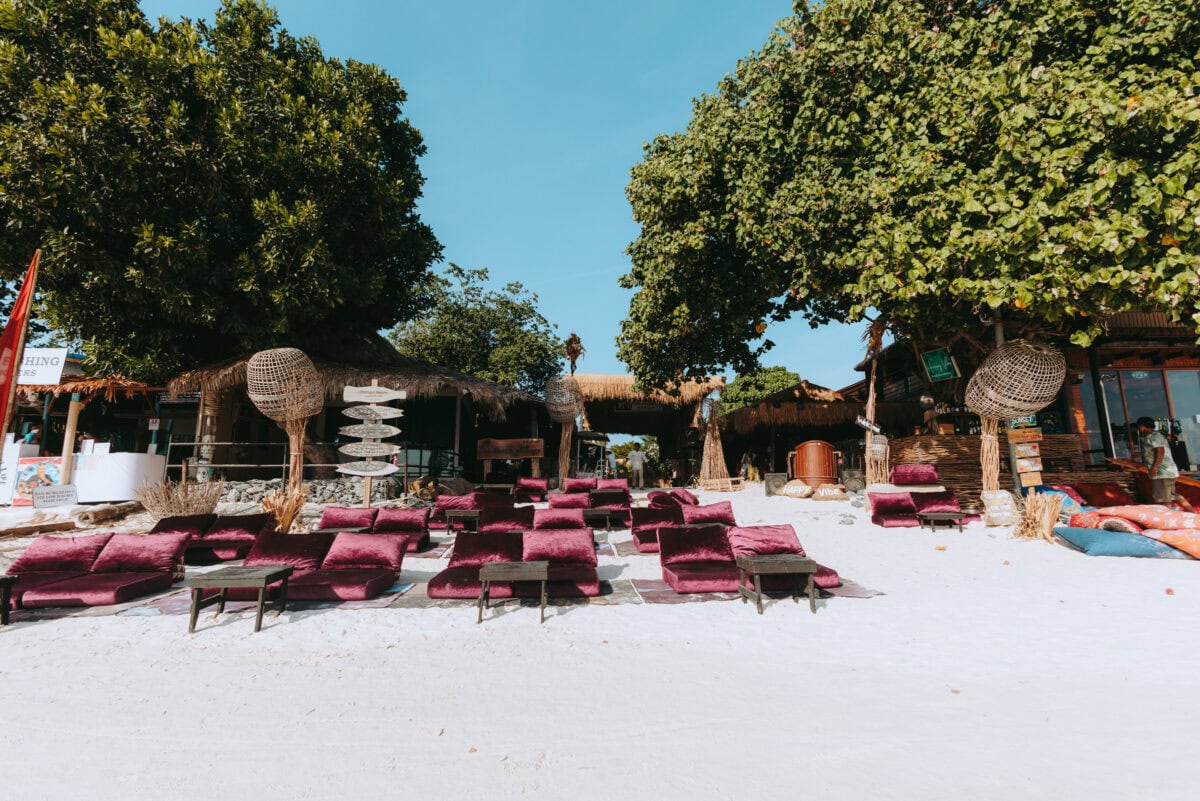 Strandbar mit roten Kissen im weißen Sand