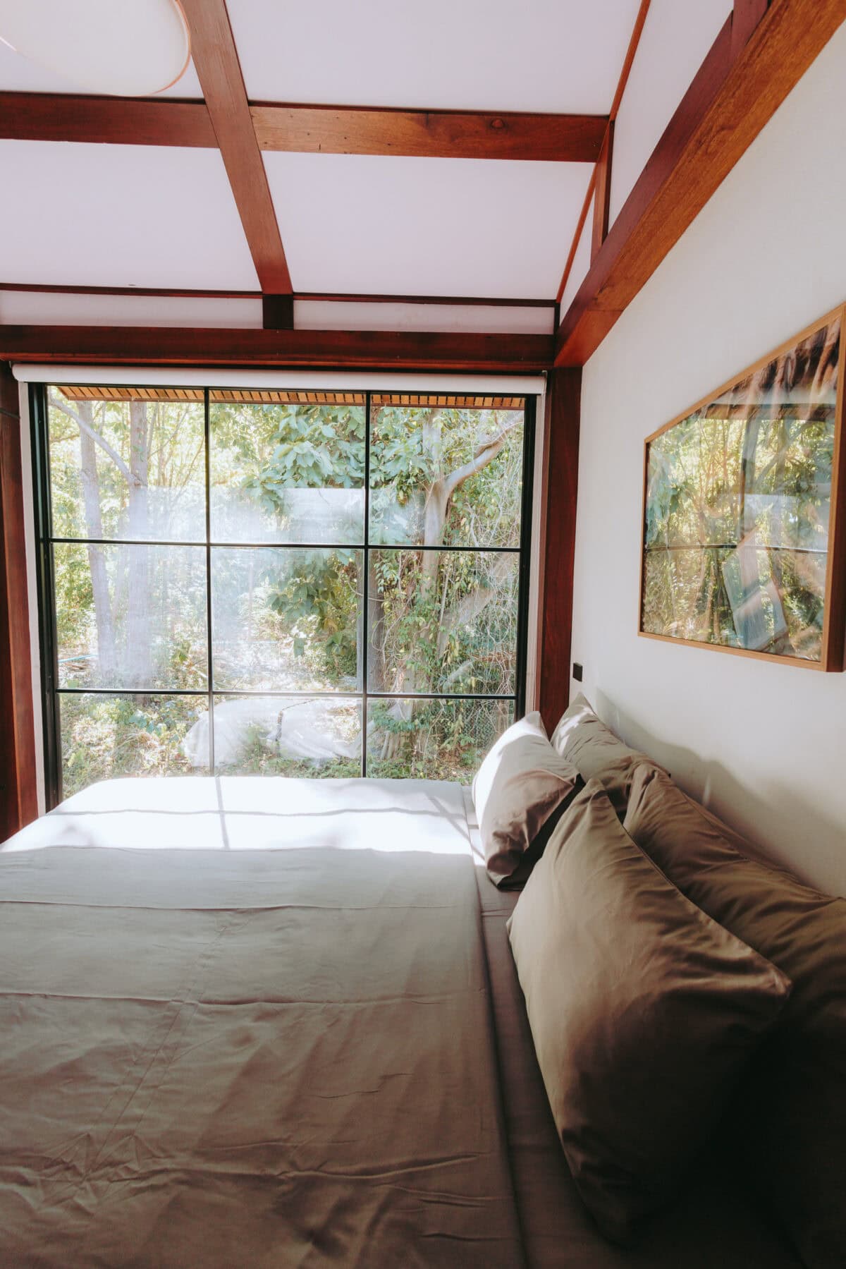 Gemütliches Schlafzimmer mit großem Fenster und Gartenblick