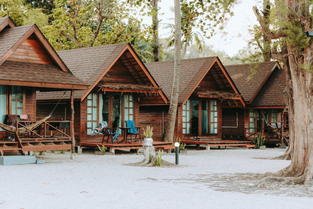 Holzbungalows am Sandstrand unter Palmen