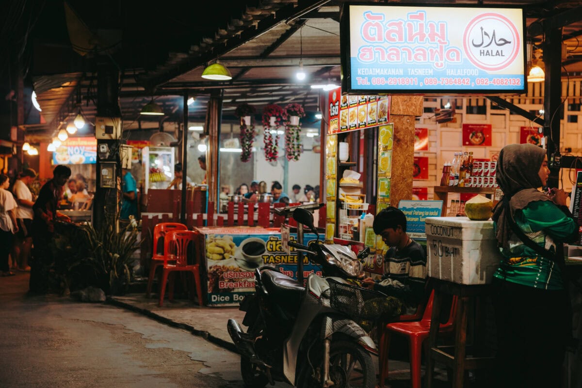 Belebter Halal‑Streetfoodstand bei Nacht