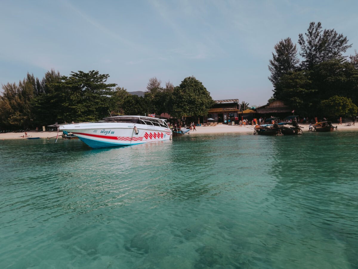 Speedboot vor tropischem Strand mit türkisfarbenem Wasser