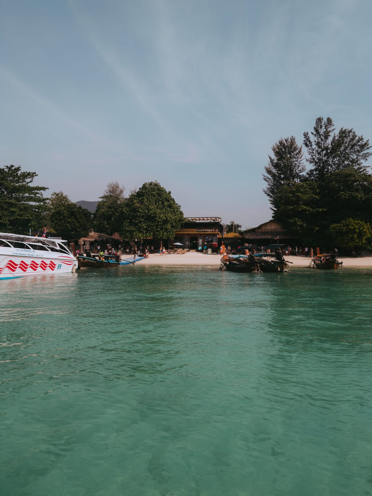 Boote vor tropischem Strand mit türkisfarbenem Wasser