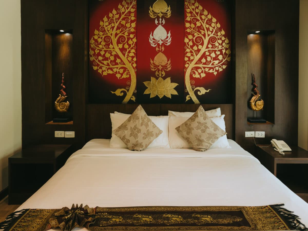 Elegantes Hotelbett mit goldener Wanddekoration