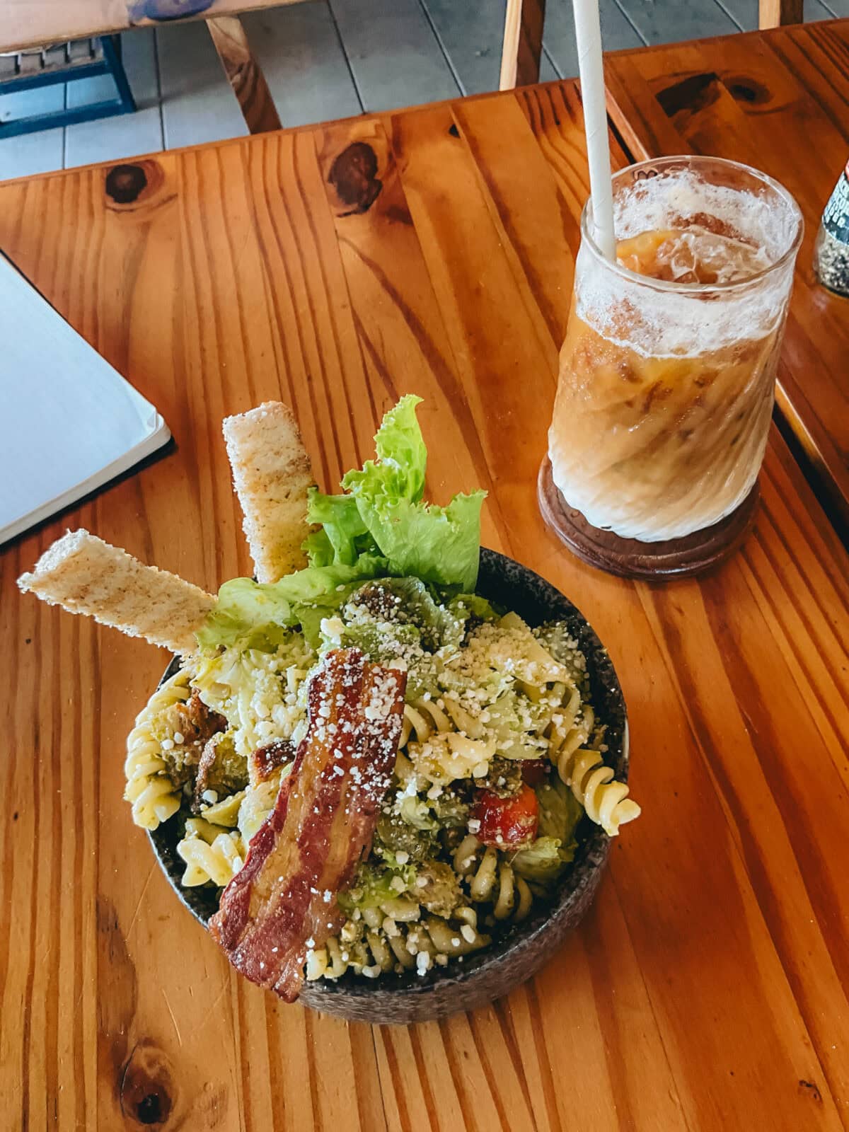 Nudelsalat mit Speck und Eiskaffee auf Holztisch
