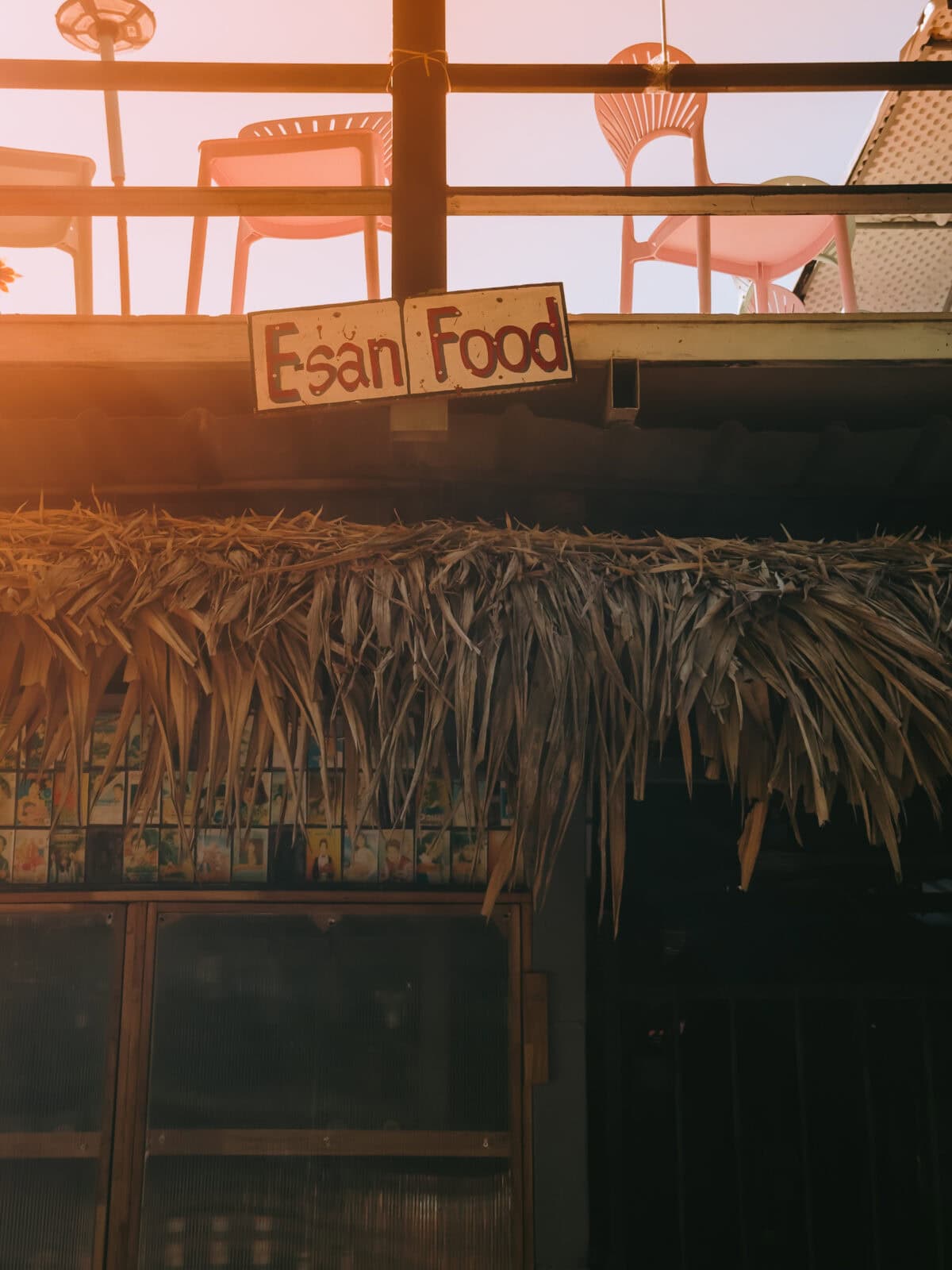 Schild „Esan Food“ an rustikalem Imbissstand