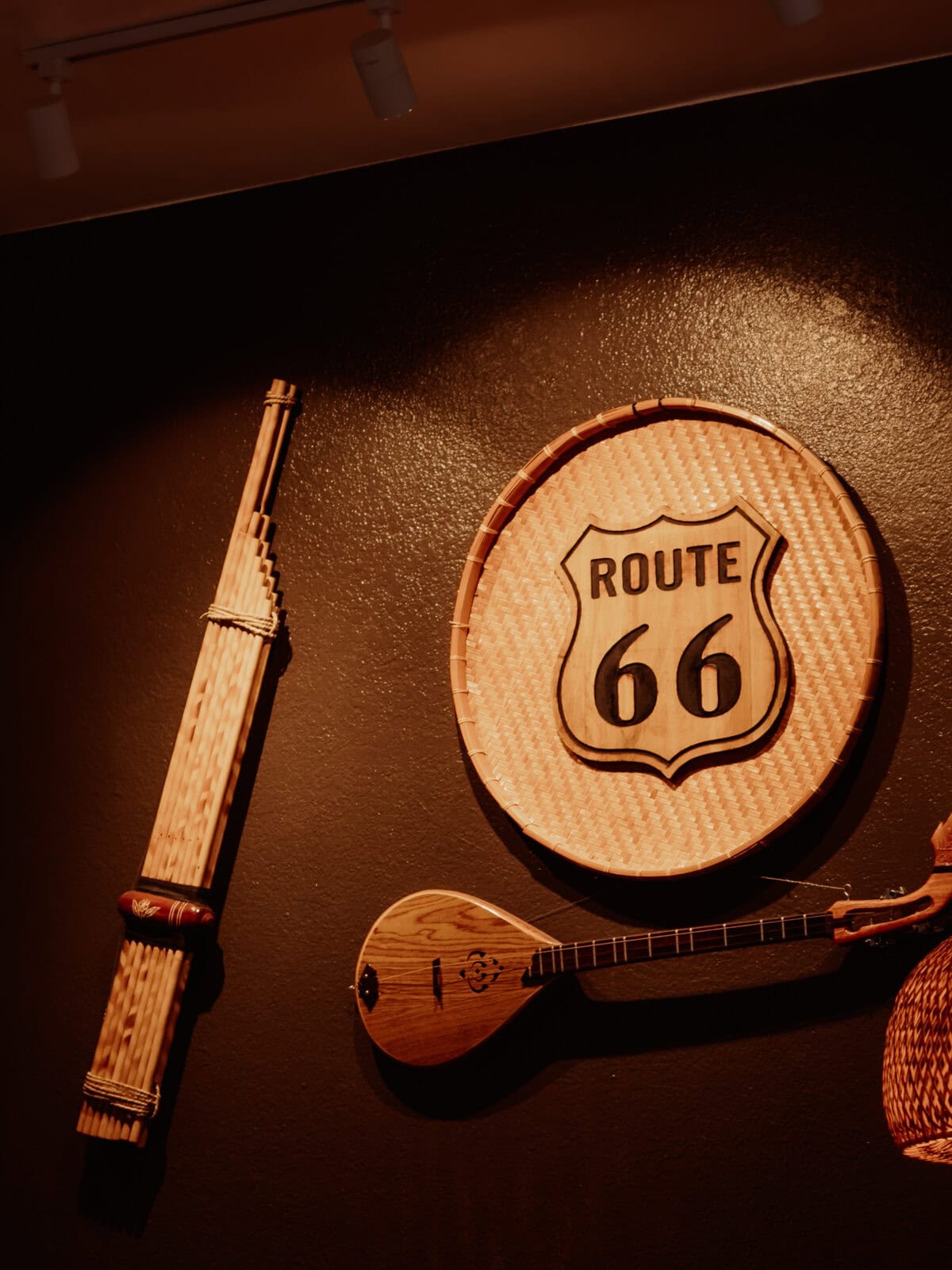 Route 66 Schild, Ukulele und Flöte an schwarzer Wand.