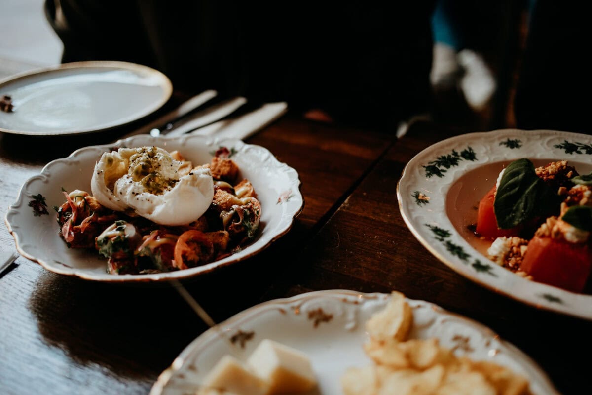 Elegante Teller mit Burrata und Tomaten auf Holztisch