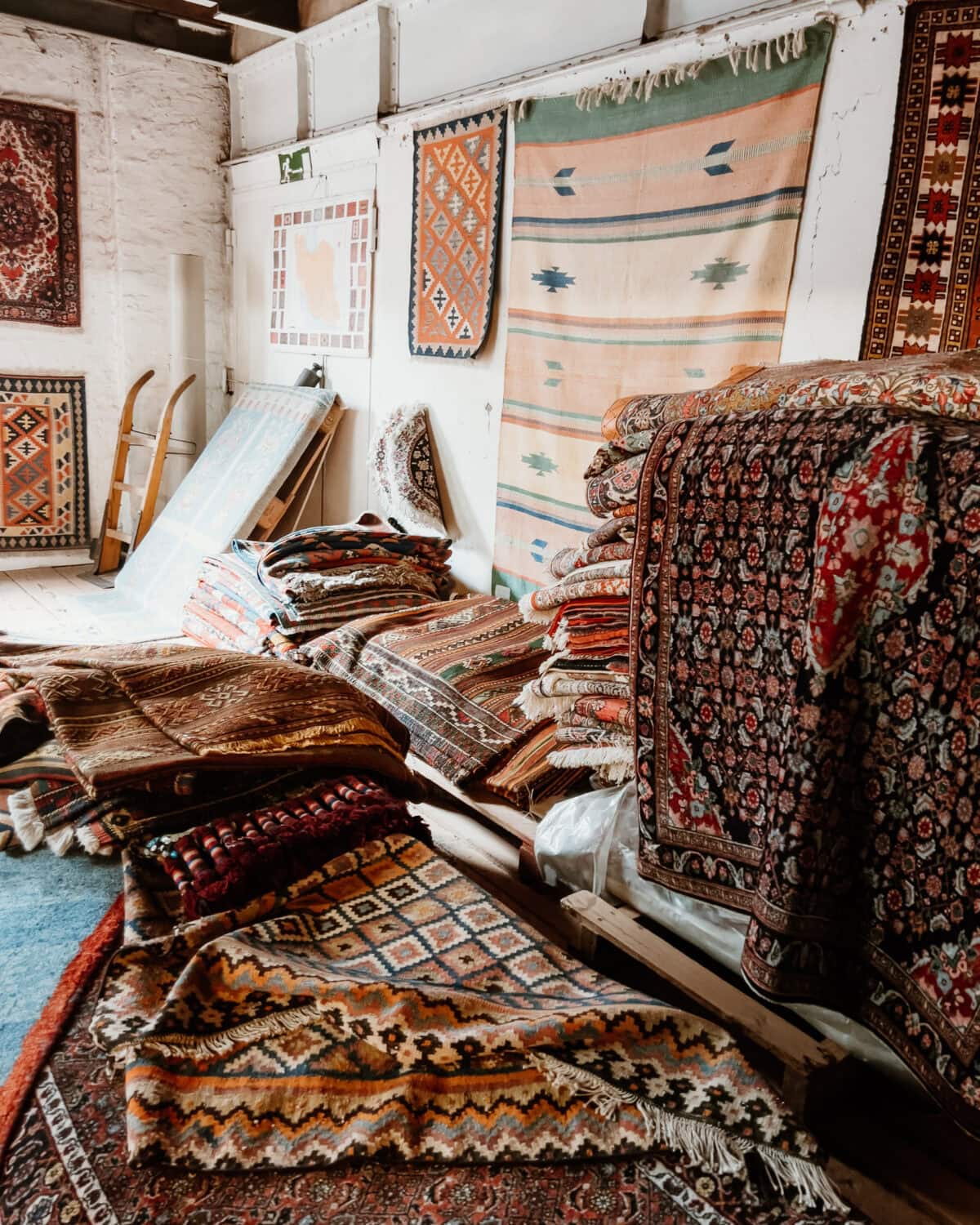 Bunte orientalische Teppiche gestapelt und aufgehängt in einem Lager