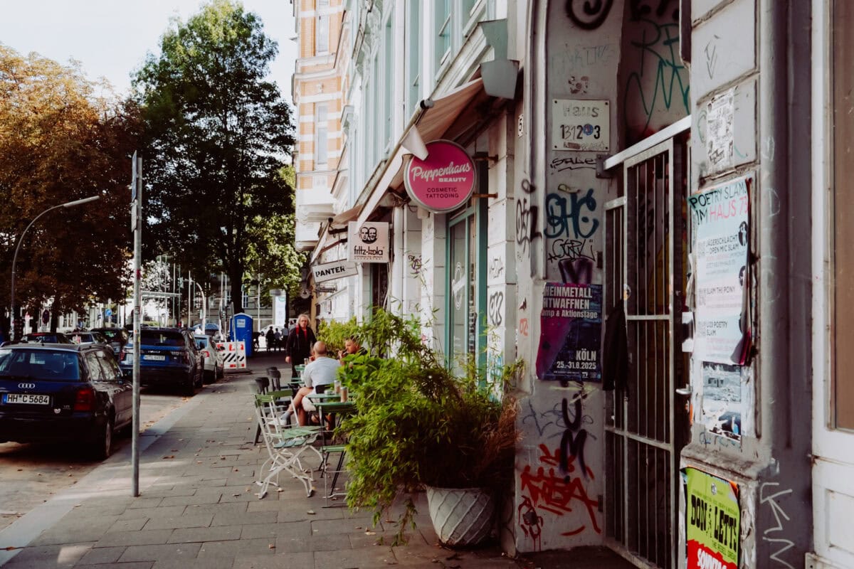 Belebte Hamburger Straße mit Café, Graffiti und Geschäften