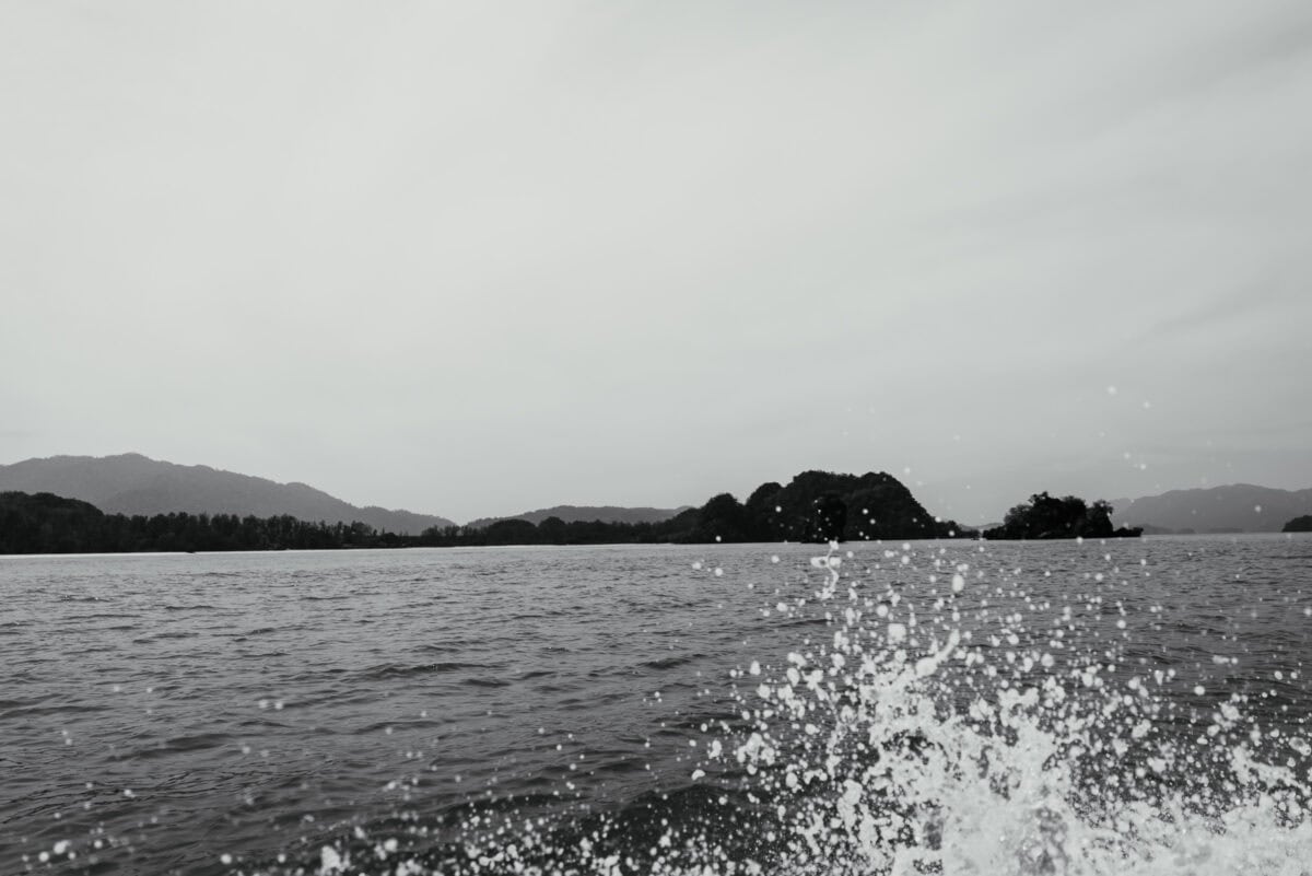 Schwarzweißfoto von Wasserspritzern mit Inseln und Bergen