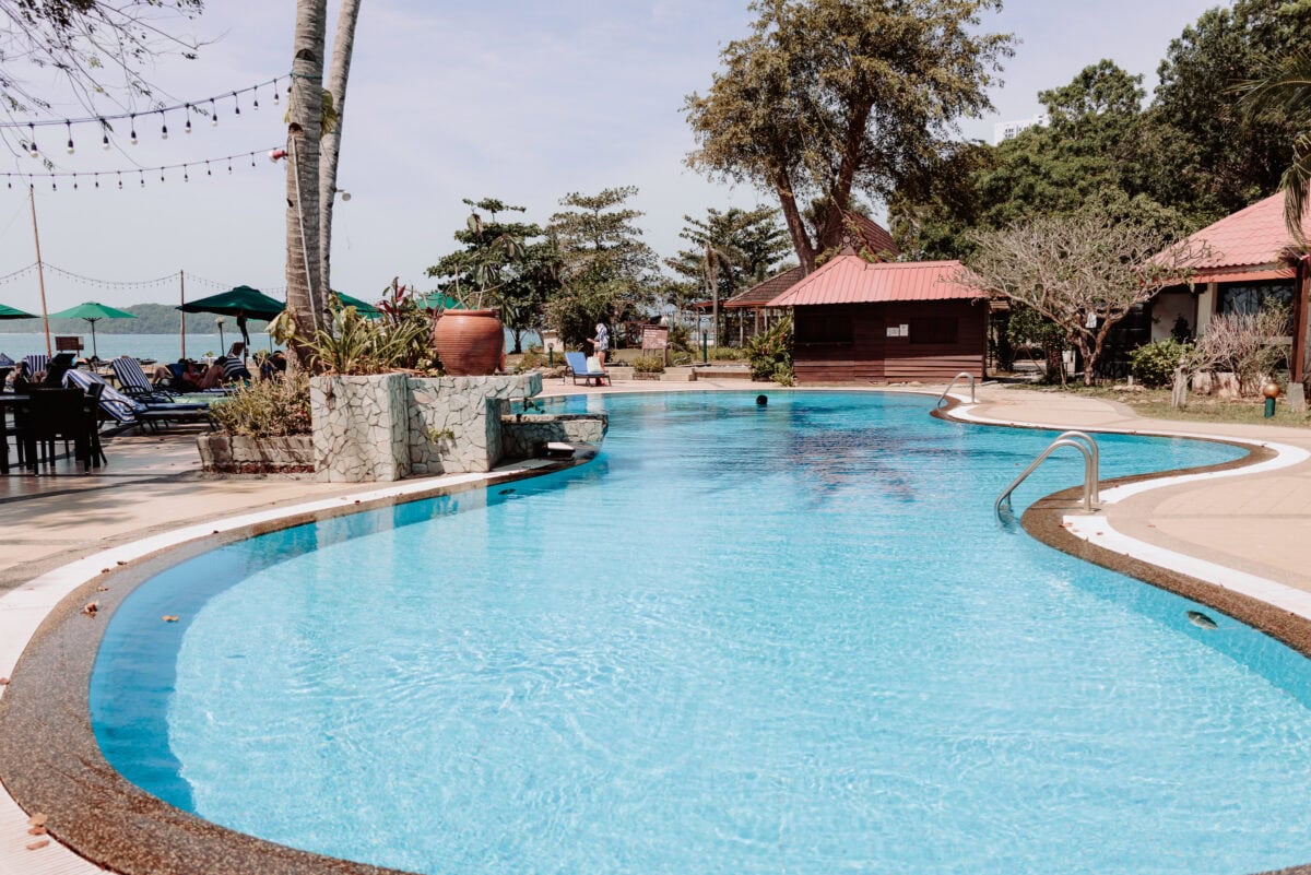 Tropisches Resort mit blauem Swimmingpool und Meerblick