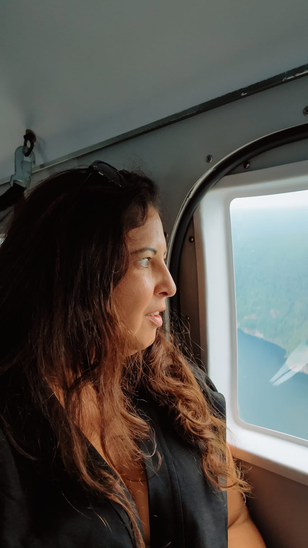 Frau schaut aus Hubschrauberfenster auf Landschaft