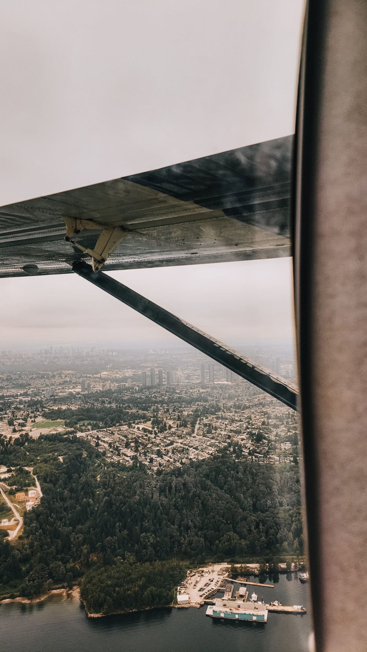 Blick aus Kleinflugzeug auf Stadt und Küste von oben