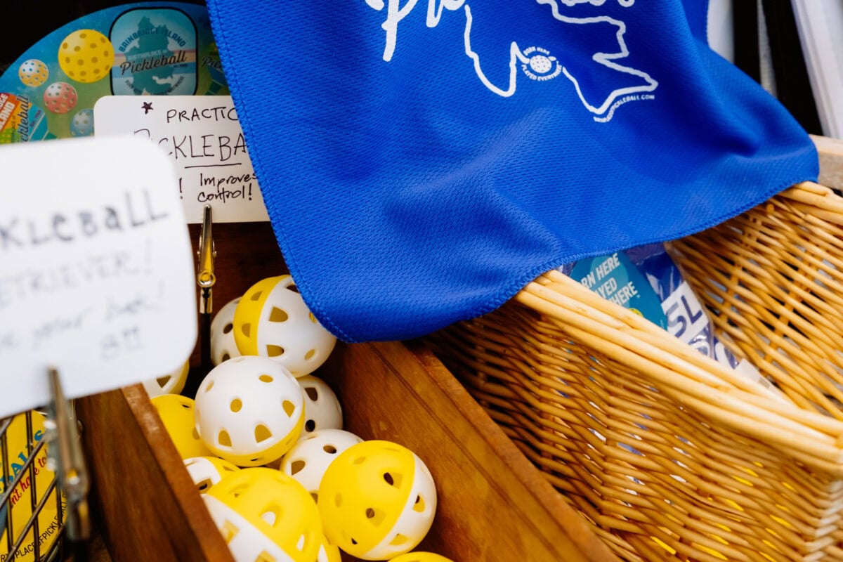 Pickleball-Zubehör mit Bällen und blauem Trikot im Korb