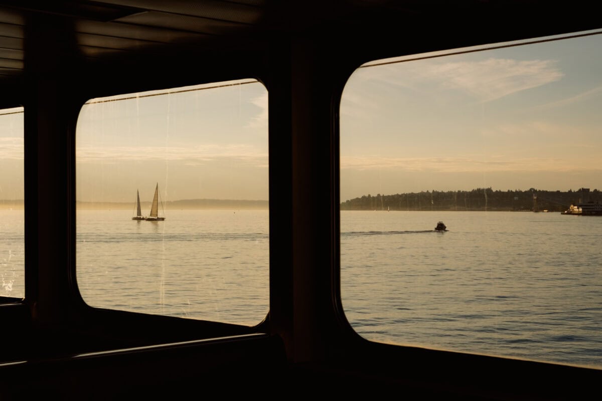 Blick aus Fähre auf Segelboote im goldenen Abendlicht