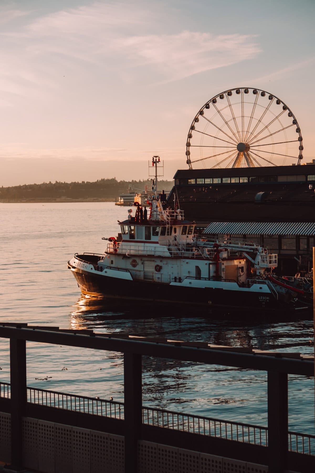 Schlepper am Hafen Seattle mit Riesenrad bei Sonnenuntergang