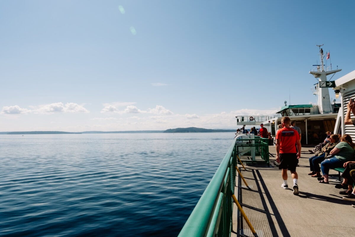Passagiere auf dem Deck einer Fähre bei ruhigem Meer