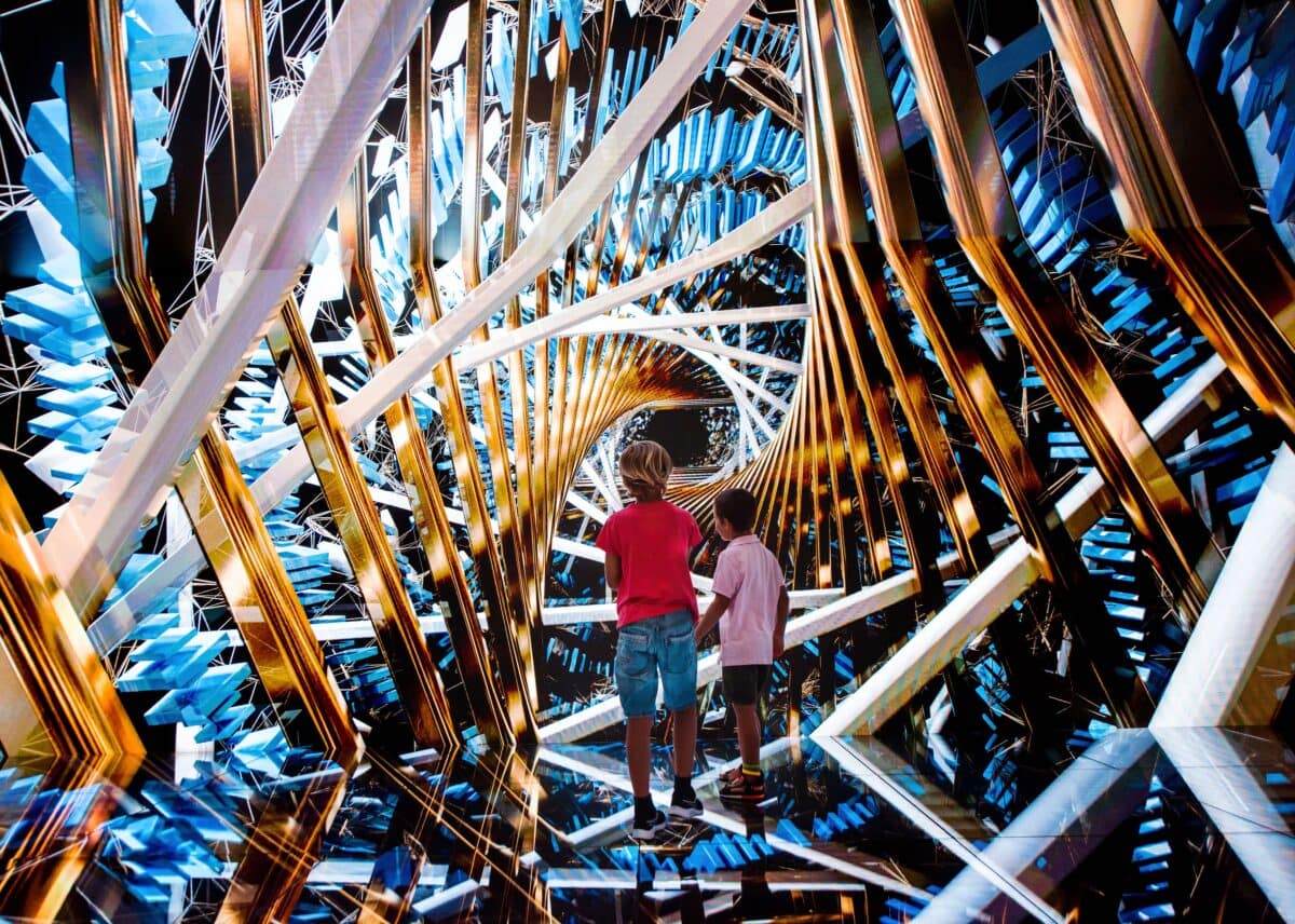 Zwei Kinder bestaunen eine Spiegelinstallation im Gaudi Cube in der Casa Battló
