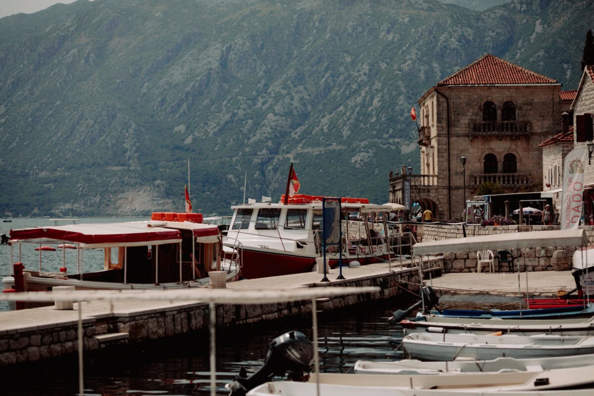 Boote im Hafen von Perast mit Bergen im Hintergrund