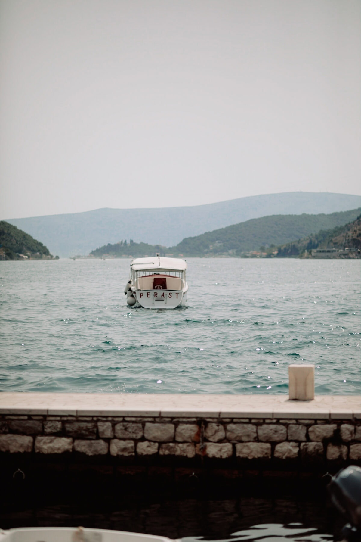 Weißes Boot namens Perast auf der Bucht von Kotor