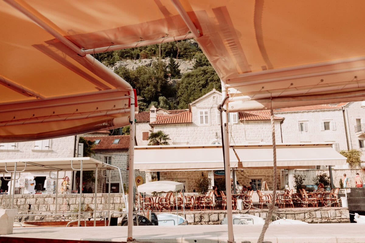 Blick vom Boot auf malerischen mediterranen Hafen mit Straßencafé