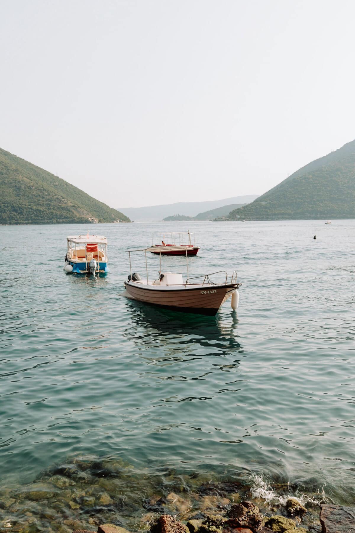Drei Boote ankern in der ruhigen Bucht von Kotor